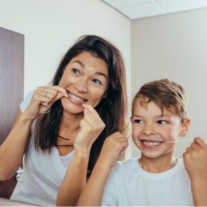 mother and son cleaning teeth with dental floss picture id863586860 1